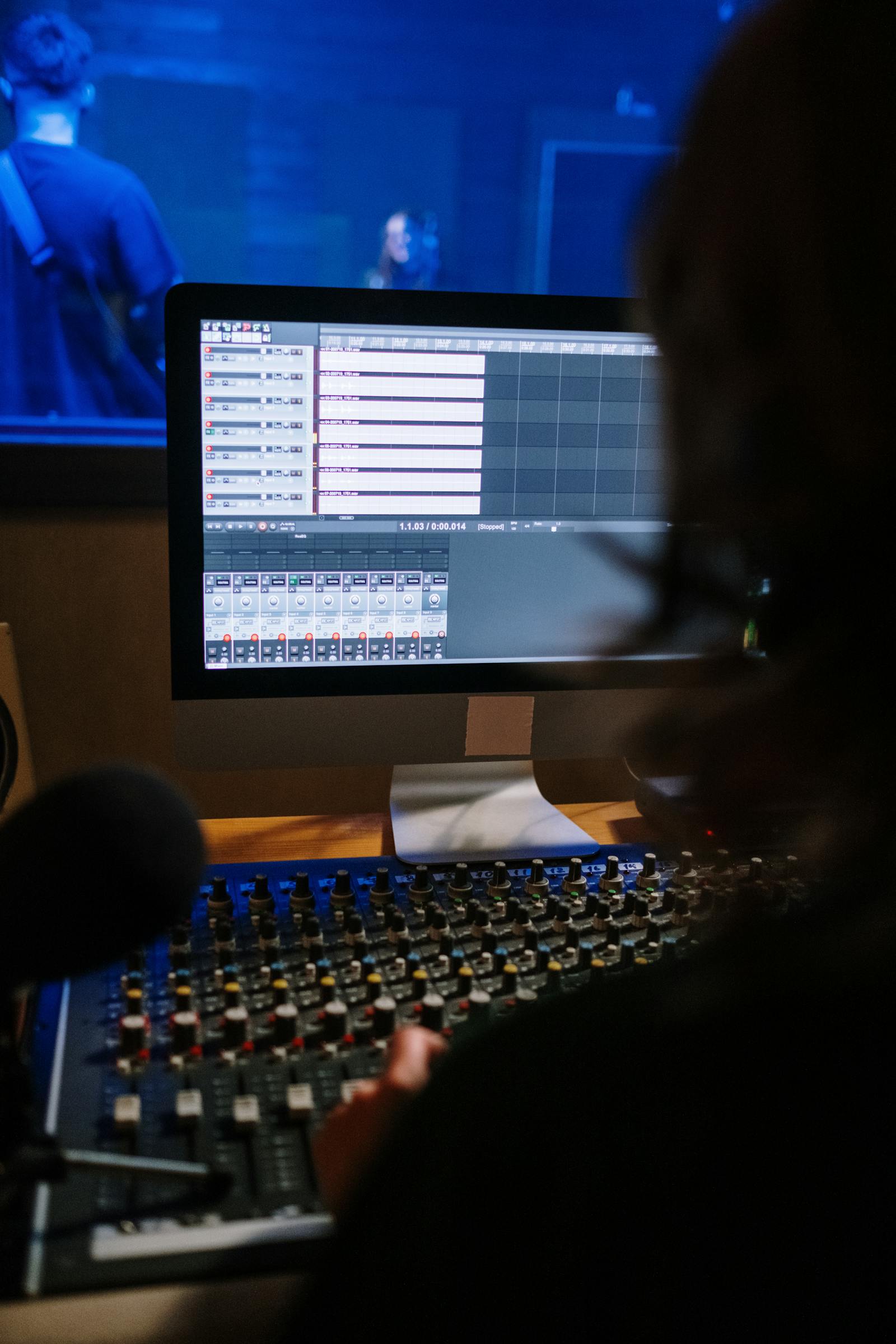 Audio engineer working at a multi-monitor studio workstation